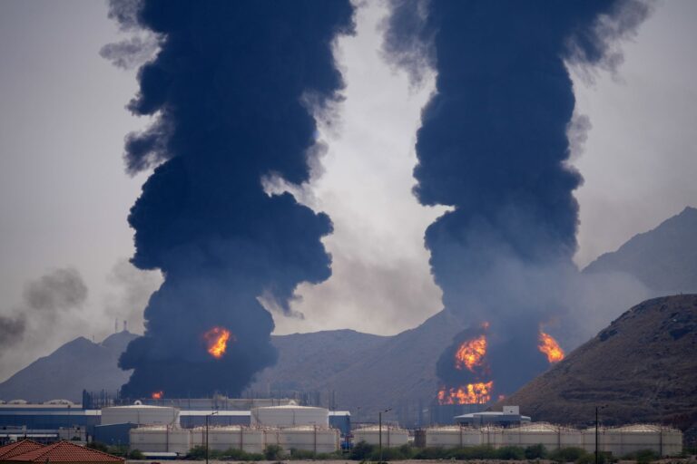 Two plumes of black smoke and fire rise from an oil facility in the United Arab Emirates.
