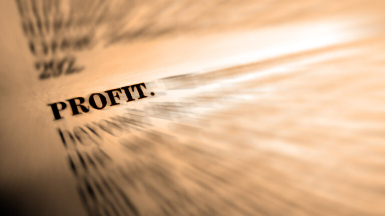 A photo illustration of a page with blurred words surrounding the word “profit.”