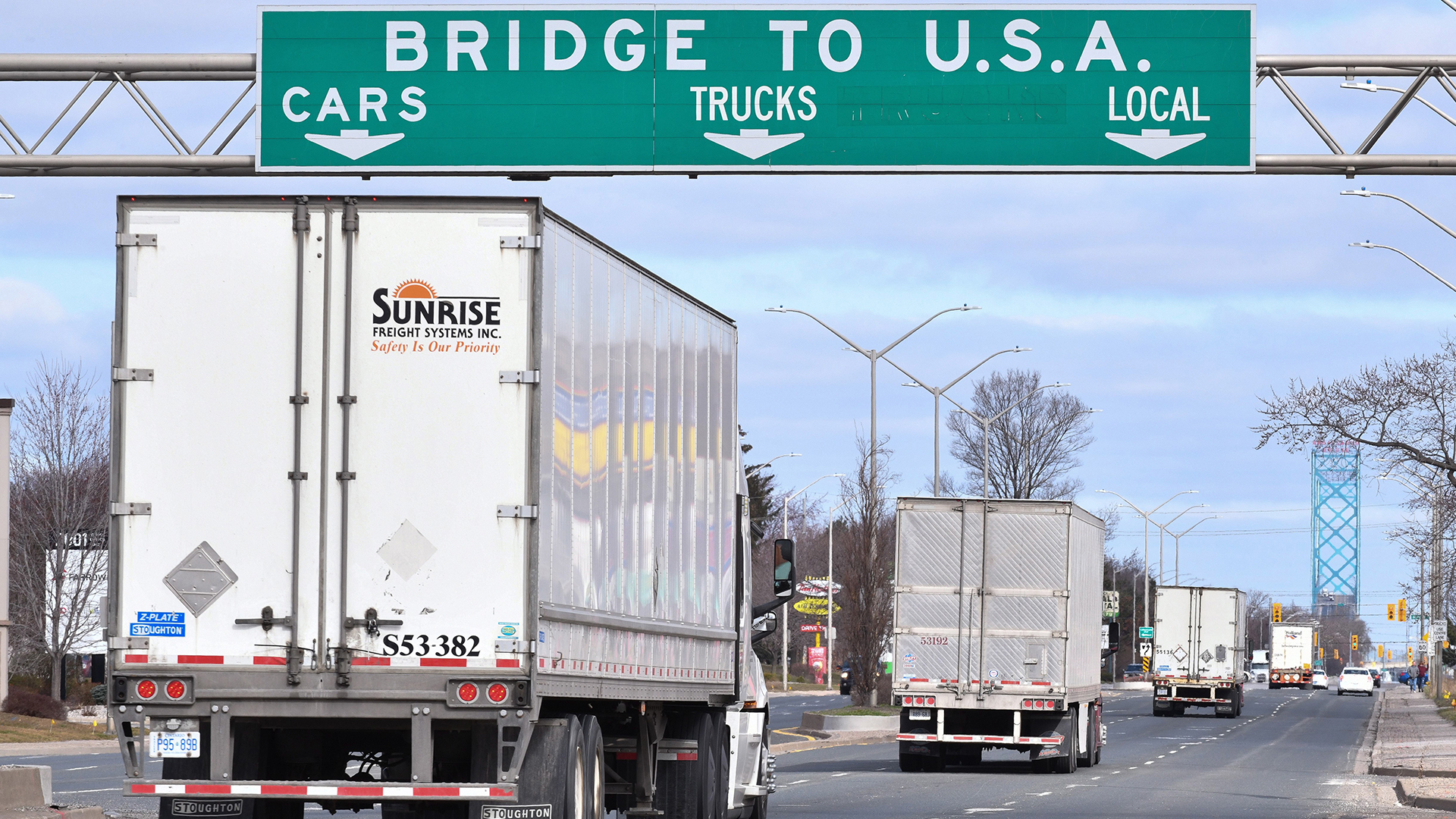 Transport trucks approach the Canada/USA border crossing in Windsor, Ont. on Saturday, March 21, 2020.