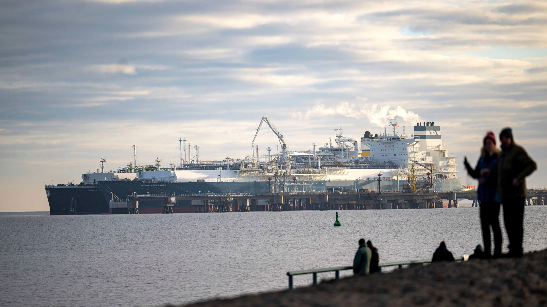 The tanker is docked alongside another ship at a jetty. 