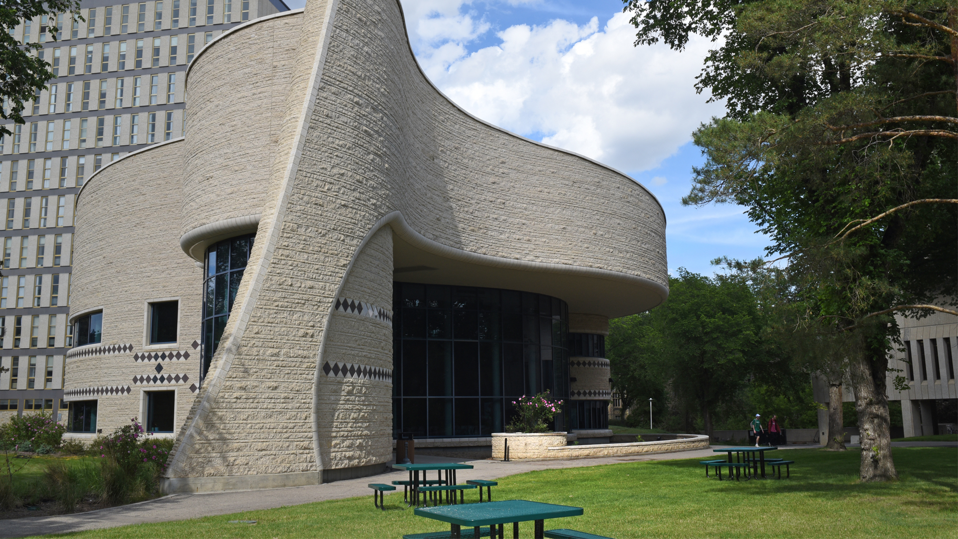 The building is several storeys high with walls that curve into a couple of semi-circles. It’s covered in textured concrete.