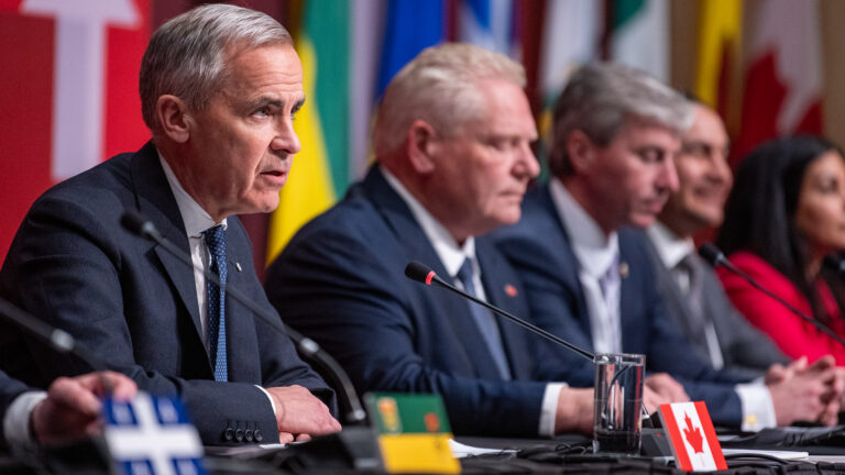 Mark Carney est assis à table avec les premiers ministres canadiens. On voit le premier ministre de l'Ontario Doug Ford sur sa gauche.