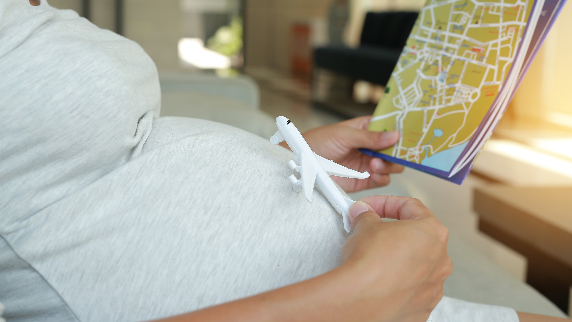 A pregnant woman looks at a map.