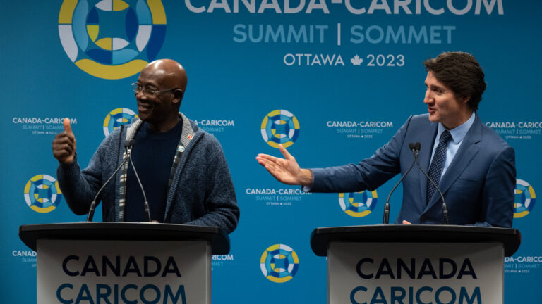 The two men are smiling as Keith Rowley gives a thumbs-up to someone off screen. screen.