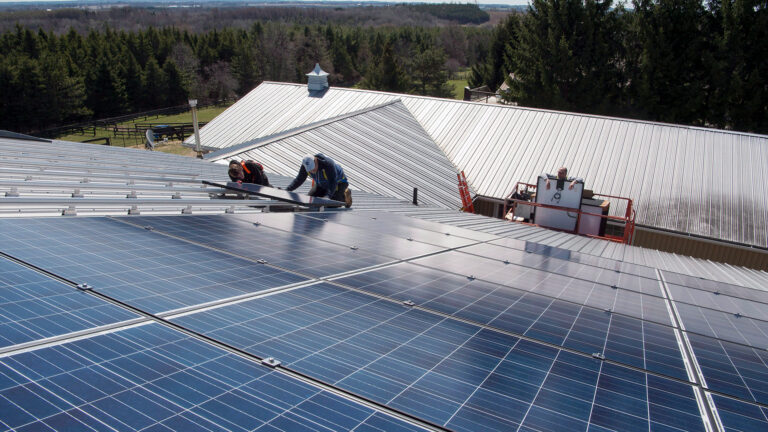 A worker installs solar panels on the roof of a house in Scugog, Ontario.