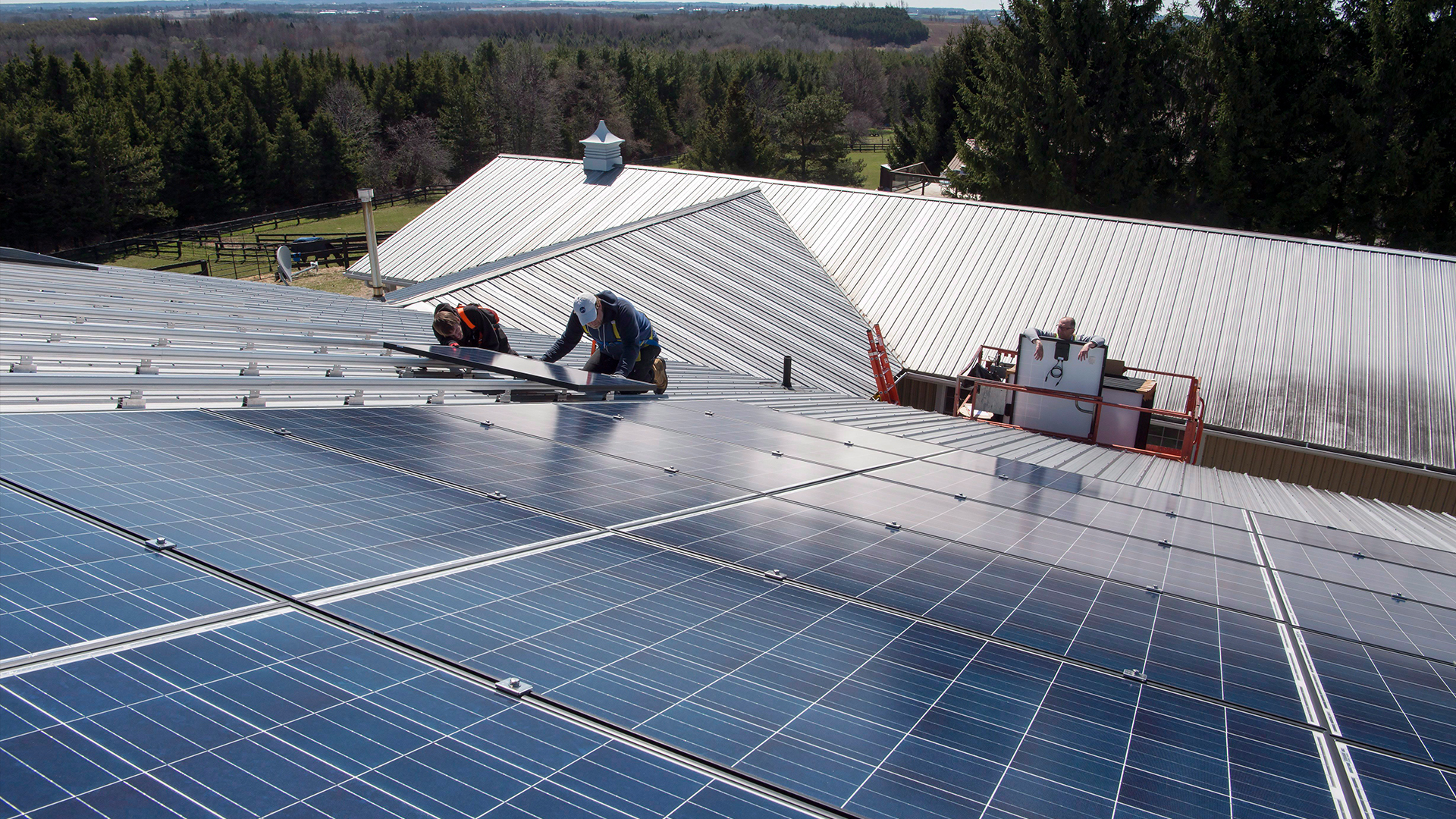 A worker installs solar panels on the roof of a house in Scugog, Ontario.