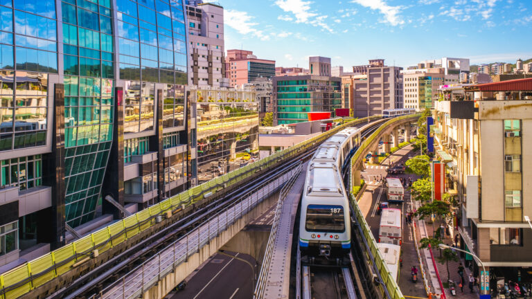 An elevated city train winds through the city, a mix of glass-front tall buildings and a lot of other buildings about seven to 10 storeys high.