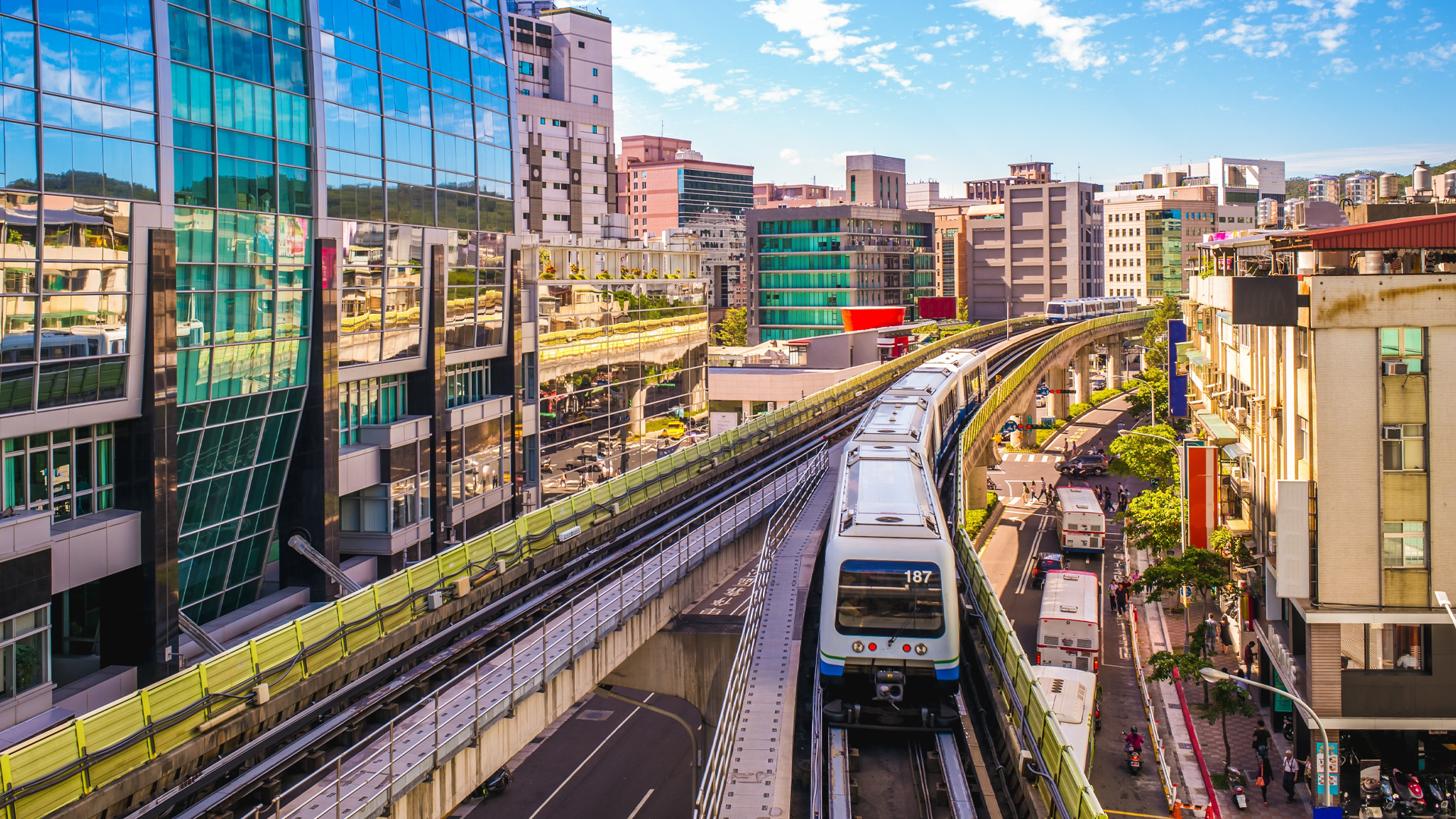 An elevated city train winds through the city, a mix of glass-front tall buildings and a lot of other buildings about seven to 10 storeys high.