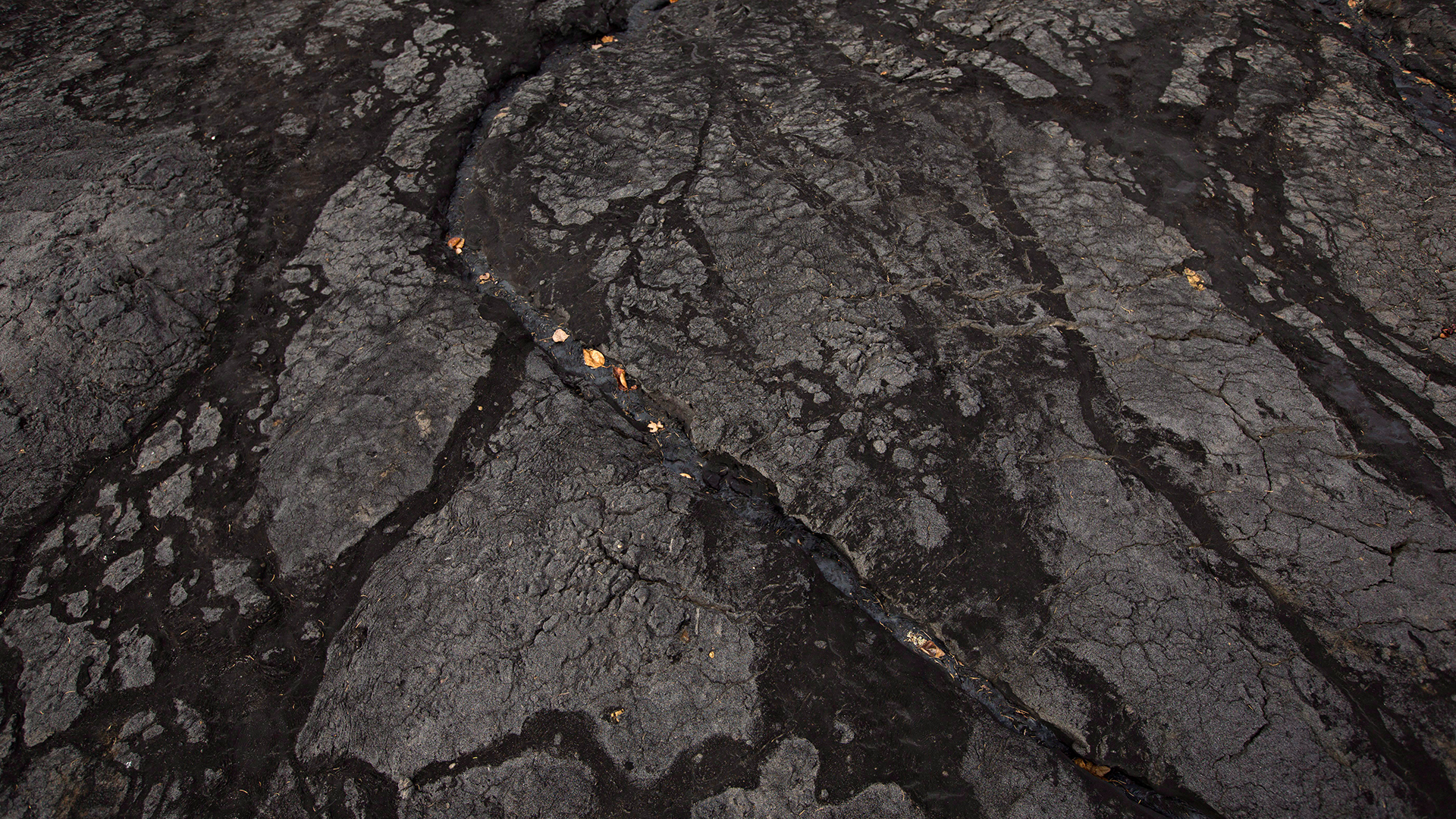 An overhead view of black oil sands.