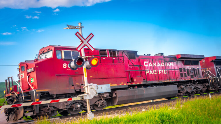 A Canadian Pacific Railway train passes through a rural crossing.