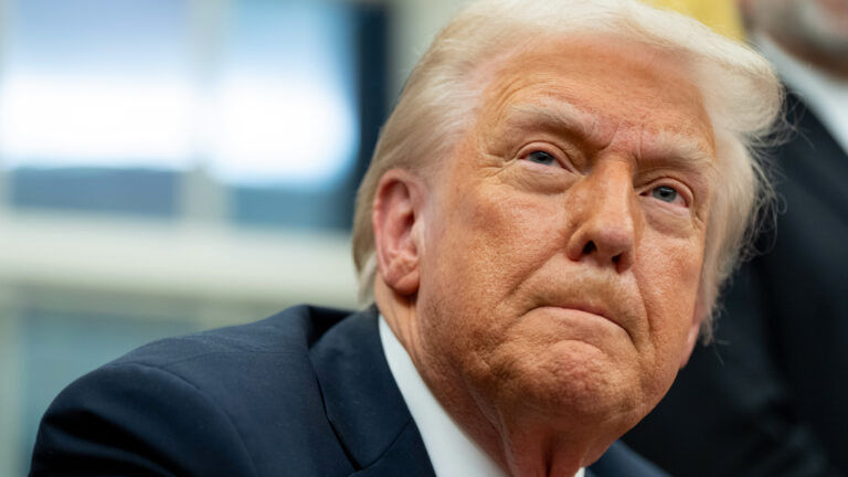 Close-up view of the face of U.S. President Donald Trump with a blurred background.