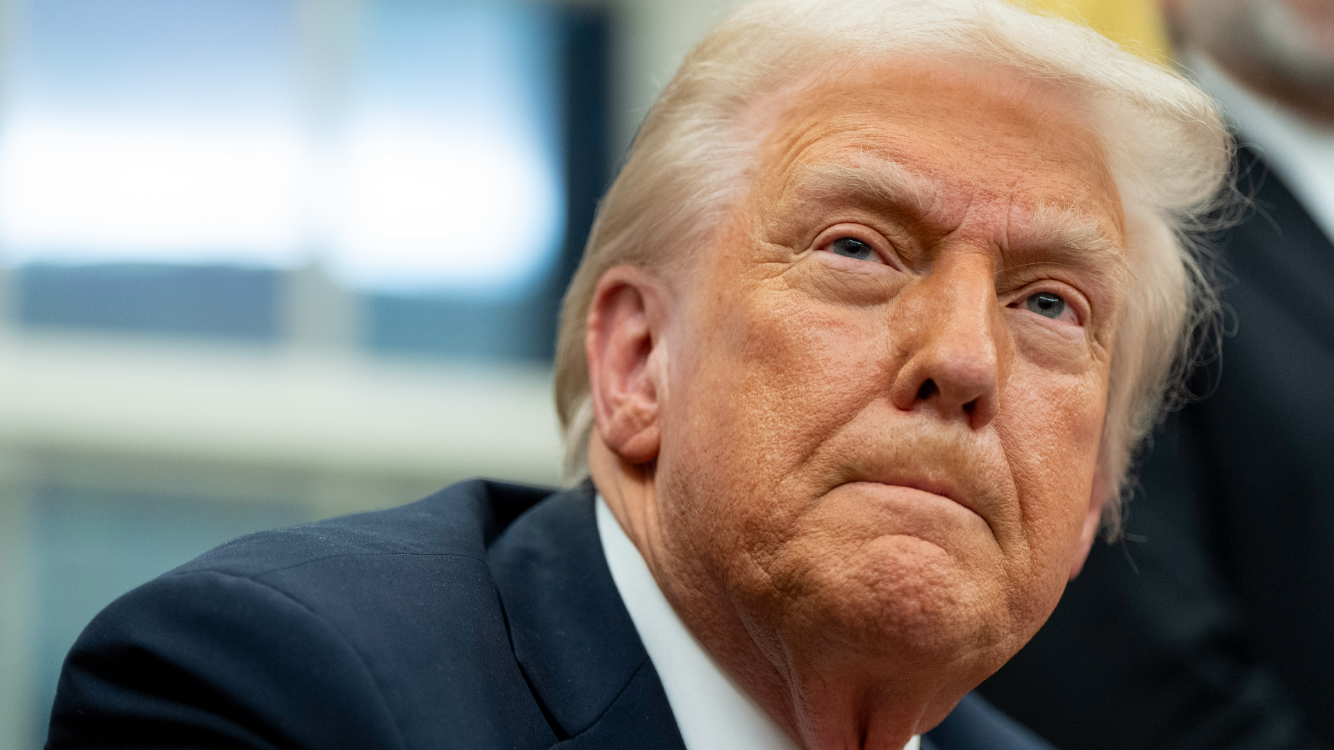 Close-up view of the face of U.S. President Donald Trump with a blurred background.