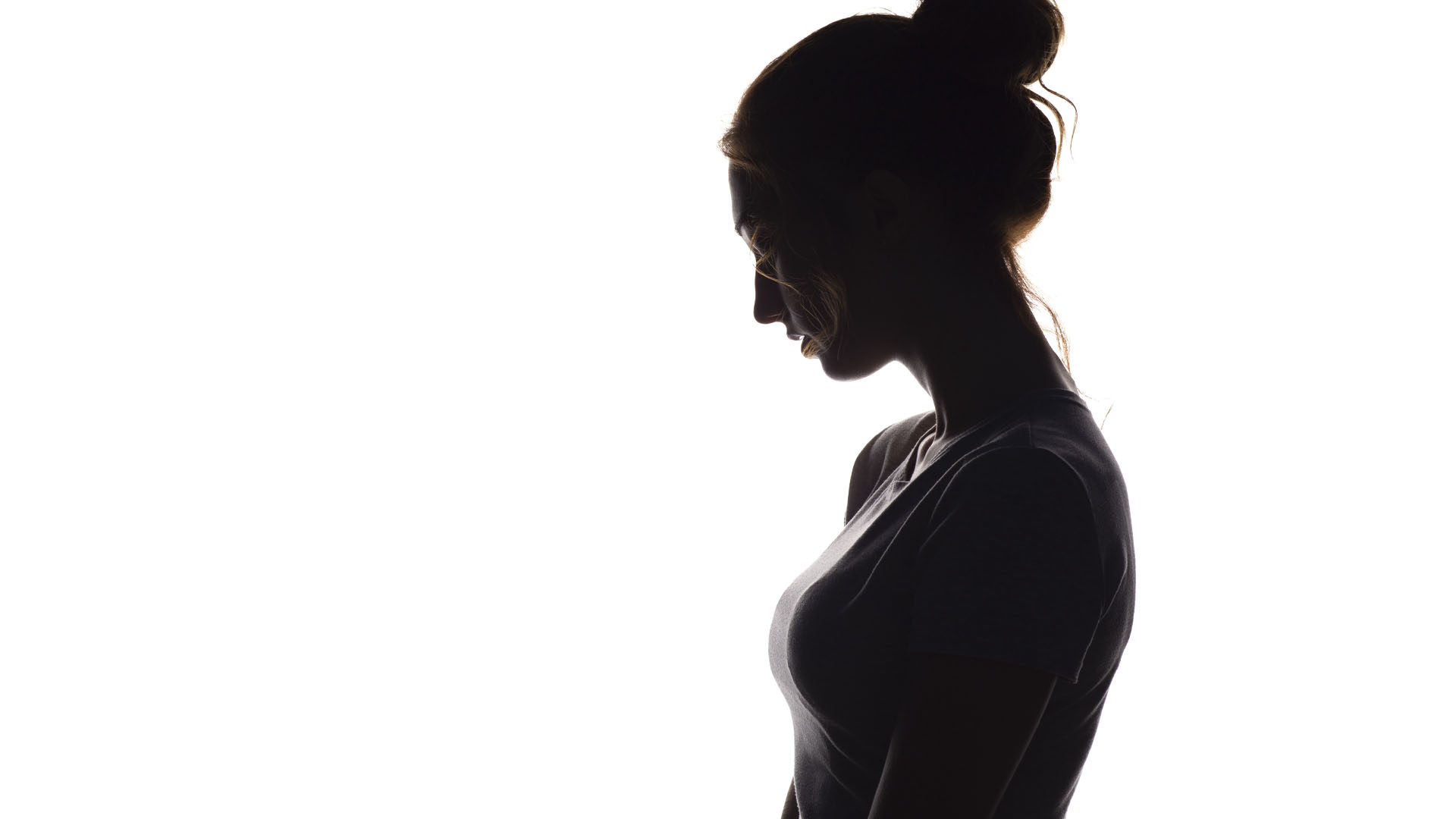 Silhouette of a young woman in a sleeveless shirt, her hair tied in a bun.