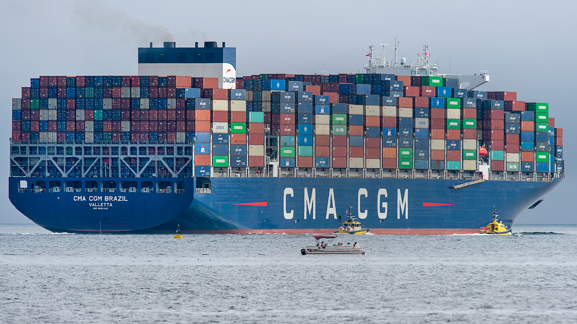 A fully-loaded container ship heads out to sea.