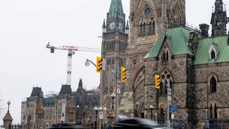 The ornate stone buildings have tall green-hued copper roofs.
