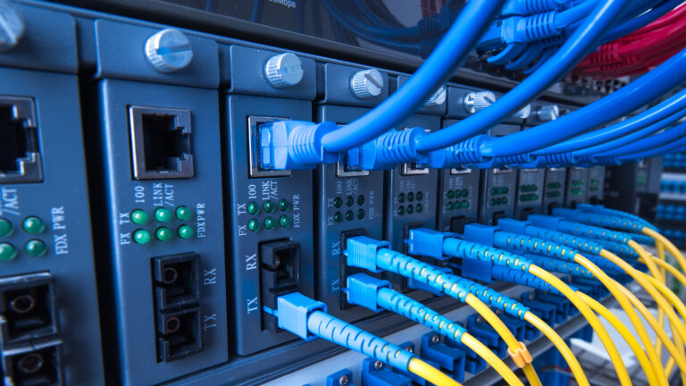 A boring closeup of a computer server, with yellow and blue cables coming out of it.