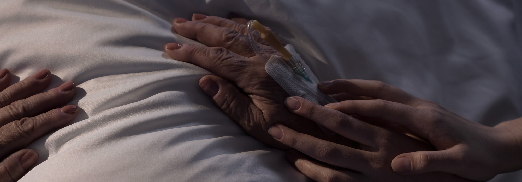 daughter-touching-hands-of-her-ill-mum