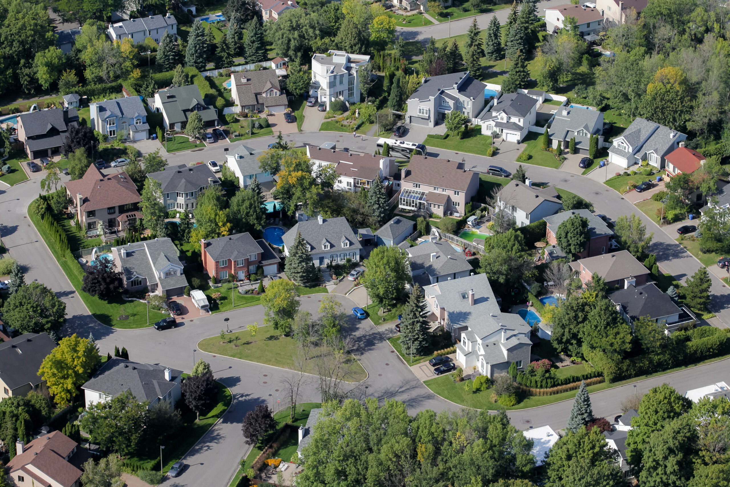 Several streets of single-family homes with small yards and evergreen trees. The streets have no sidewalks.