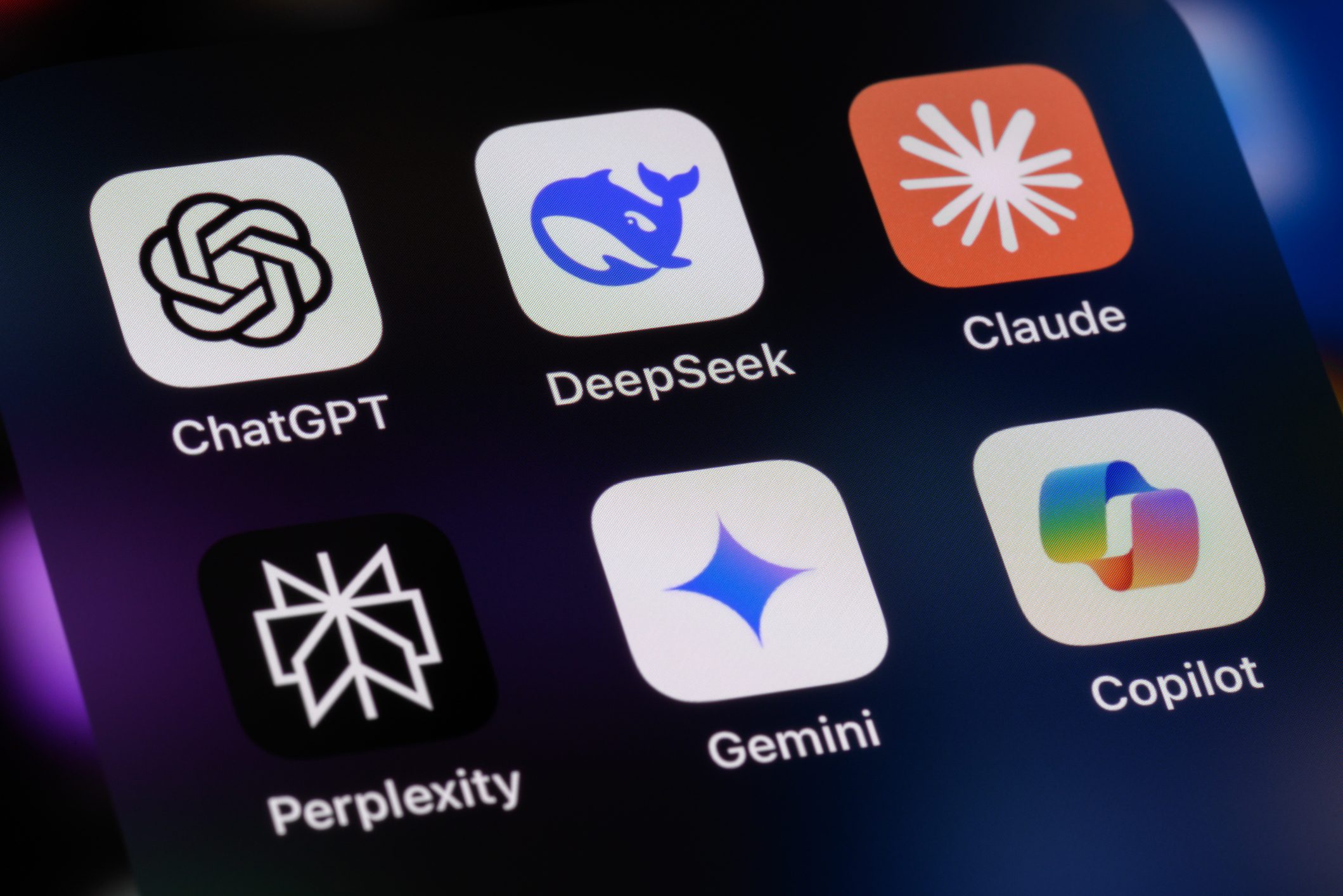 The language learning model app logos on an iphone, including ChatGPT, DeepSeek, Anthropic Claude, Perplexity, Google Gemini, Microsoft Copilot.