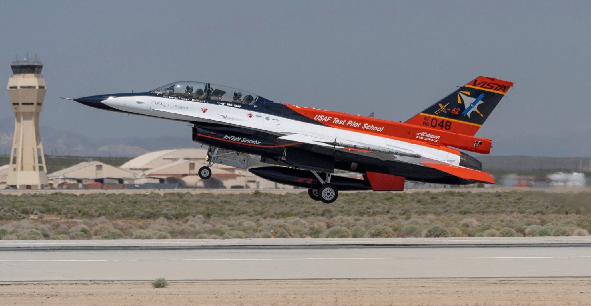 A red and white fighter jet takes off with two passengers aboard.