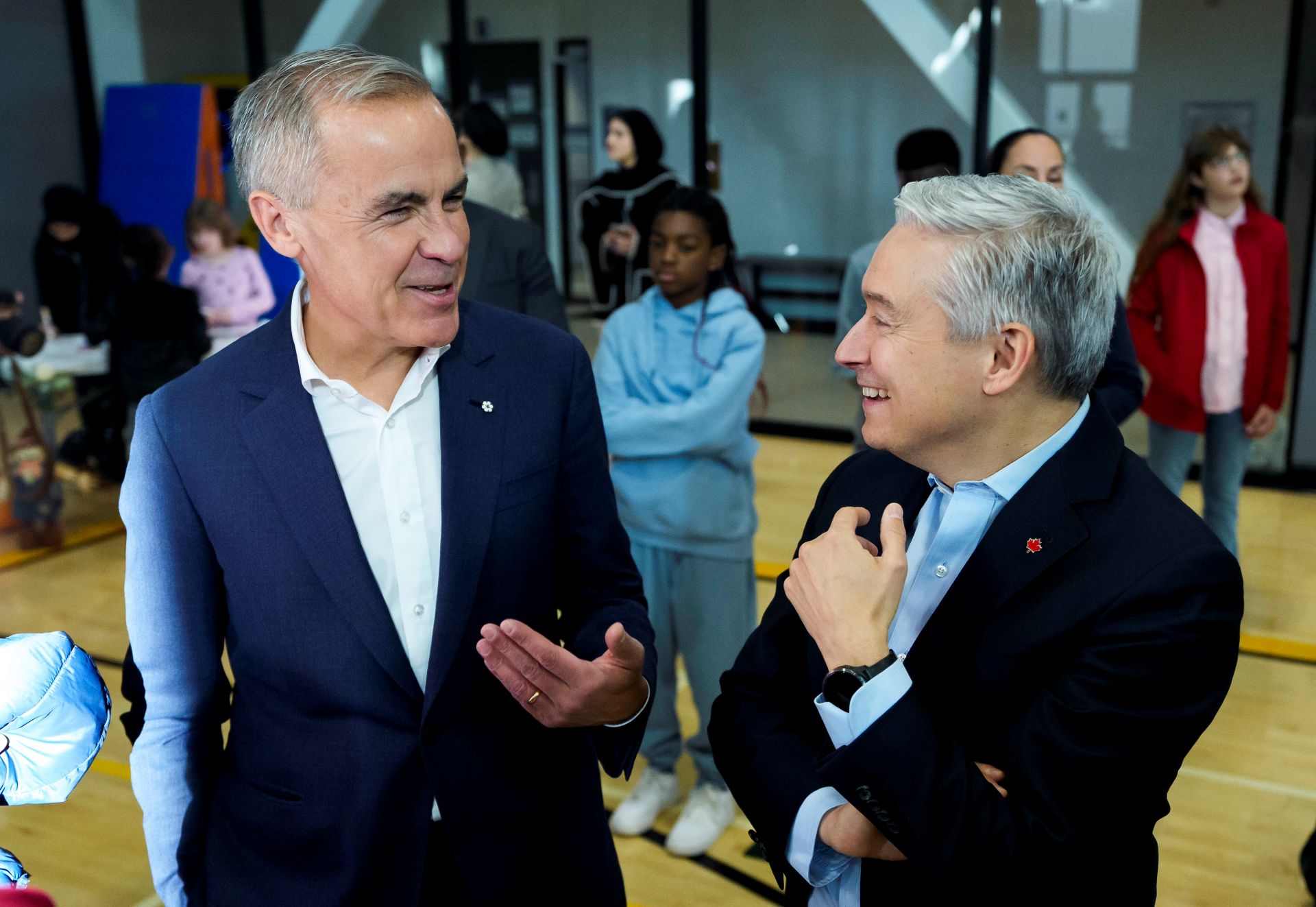 CP175138633 Fiscal rules Mark Carney and François-Philippe Champaign joke together while children stand in the background looking unimpressed.
