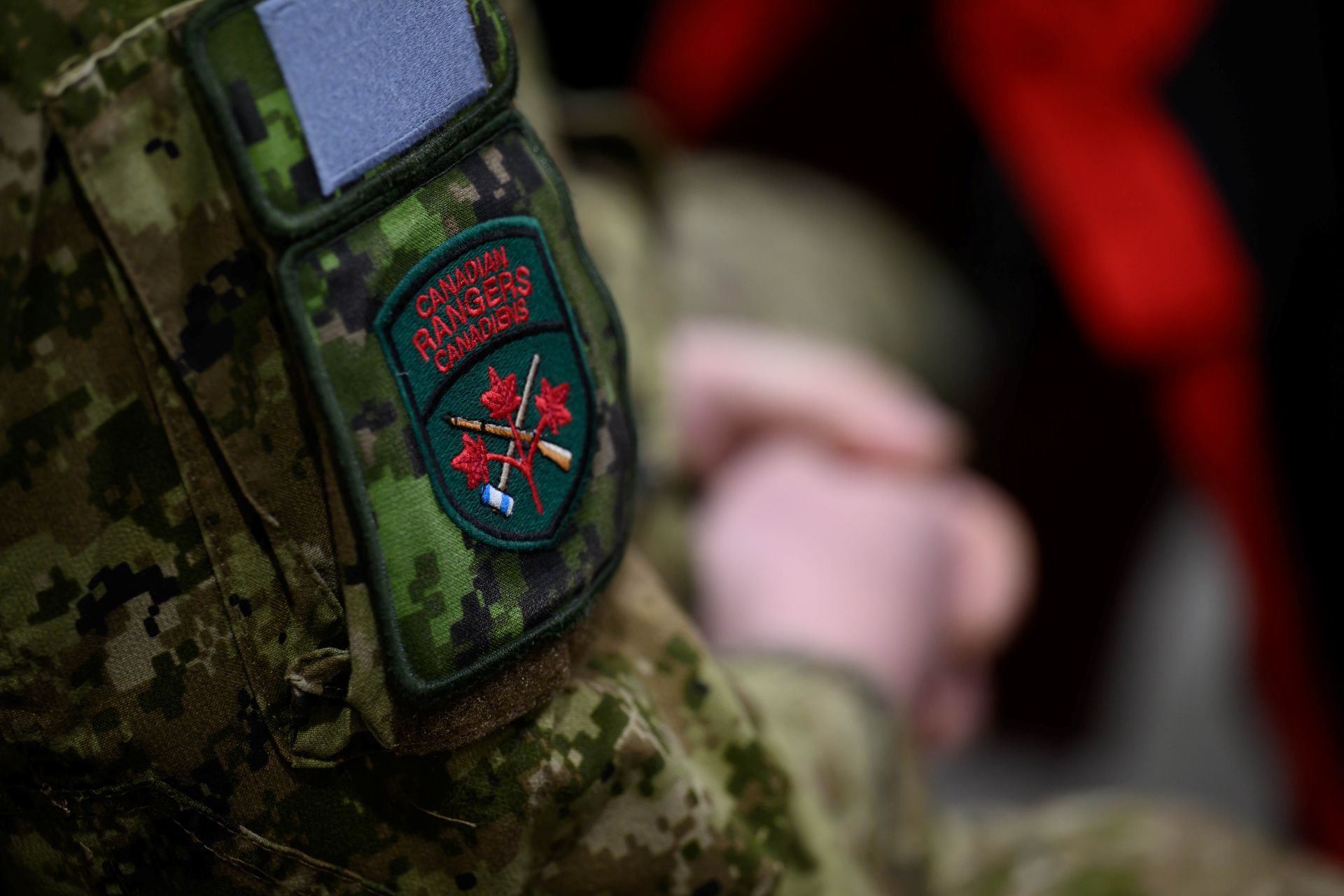 Closeup of a Canadian Rangers patch on the arm of a Canadian Forces uniform, which has camouflage pattern in greens and khaki tones.