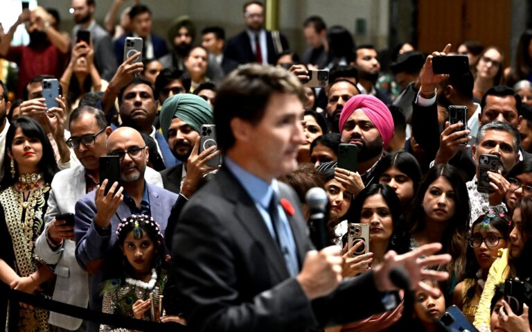 Attendees use their phones to record then-prime minister Justin Trudeau speaking.