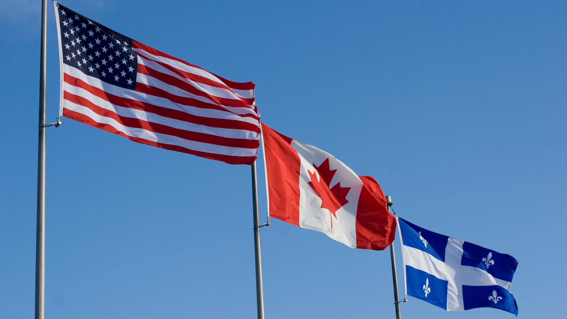 American, Canadian, and Quebec flags fly side by side.
