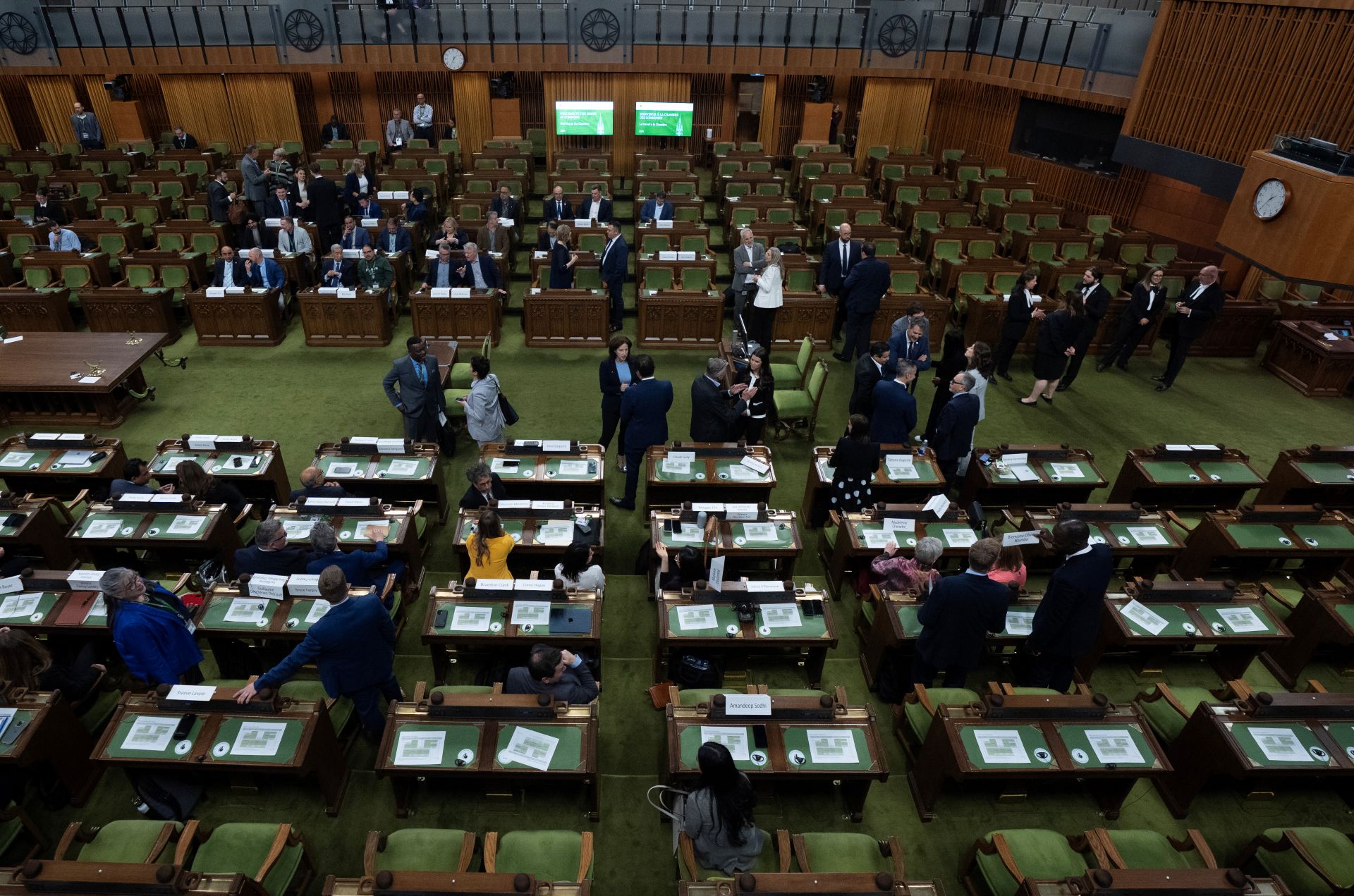 A few dozen MPs milling about and chatting in the House of Commons.