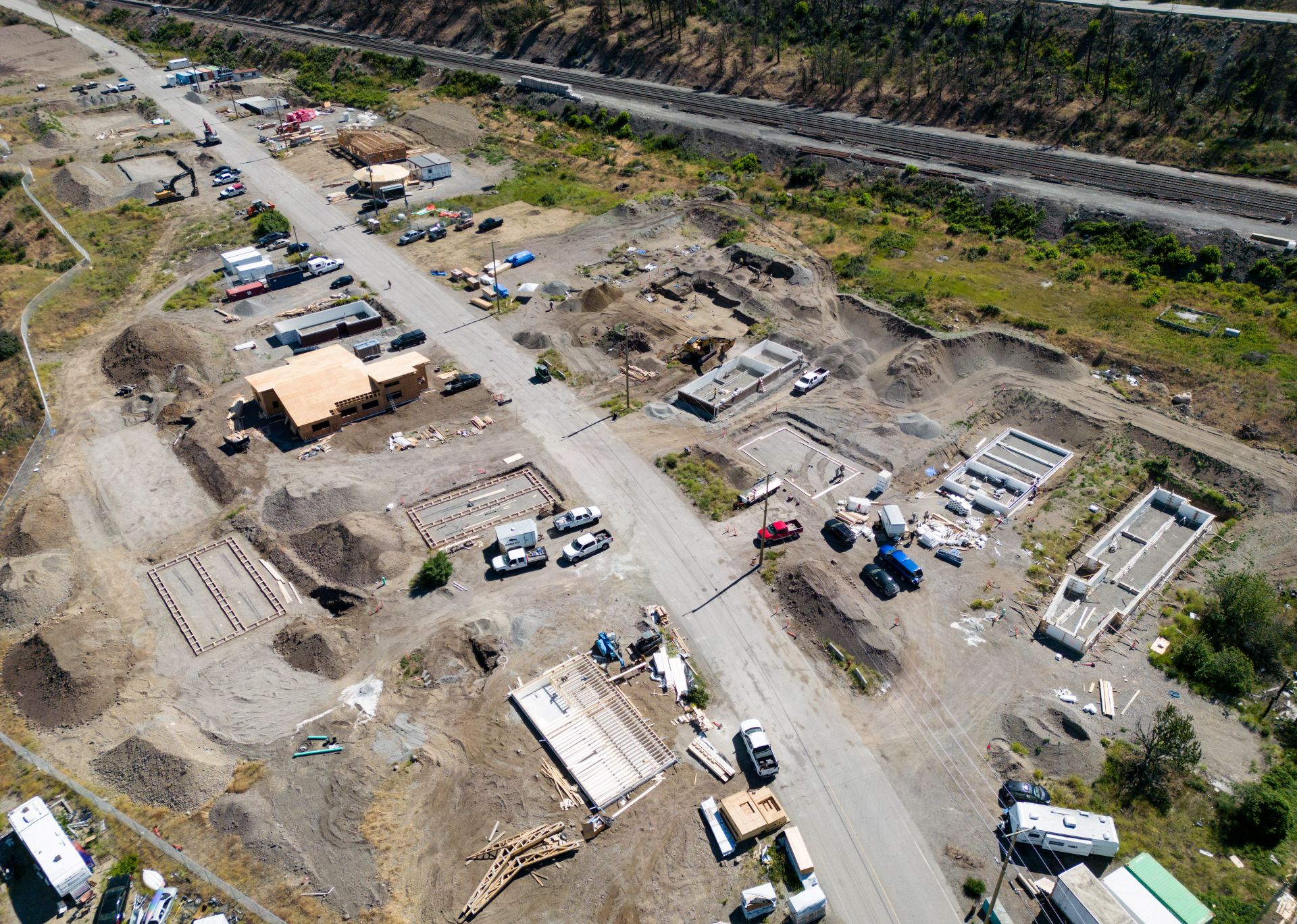 The homes, about a dozen, line both sides of a dirt road that runs parallel to a highway lined with trees.