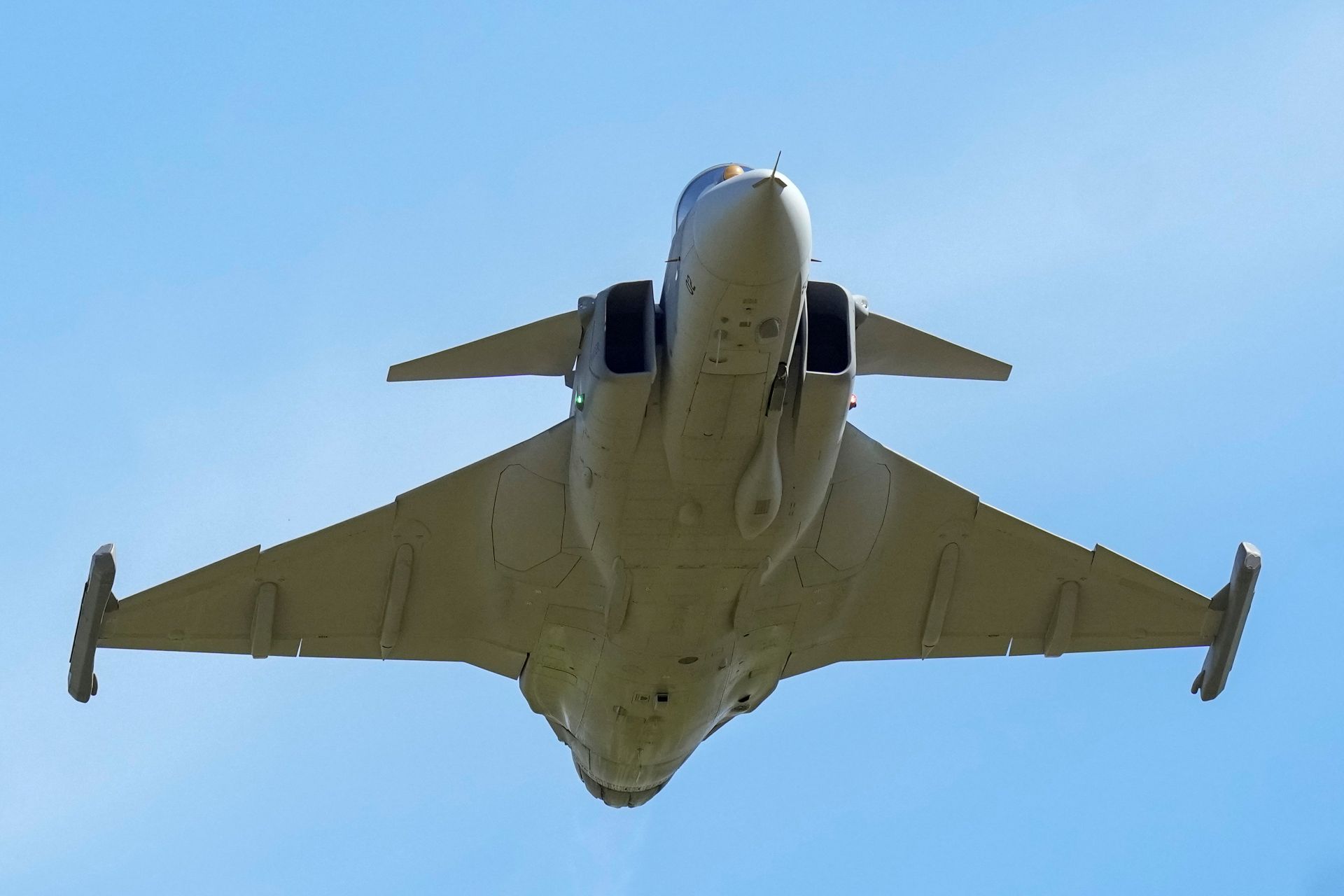 A grey SAAB Gripen F-39 photographed from below, with its distinctive small forewings visible.