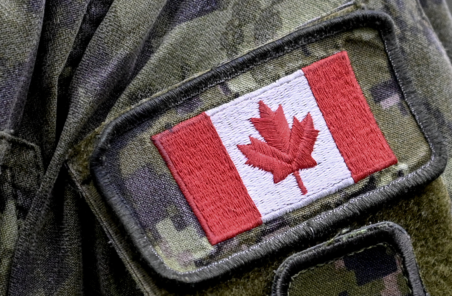 A patch depicting a Canadian flag is sewn on the sleeve.