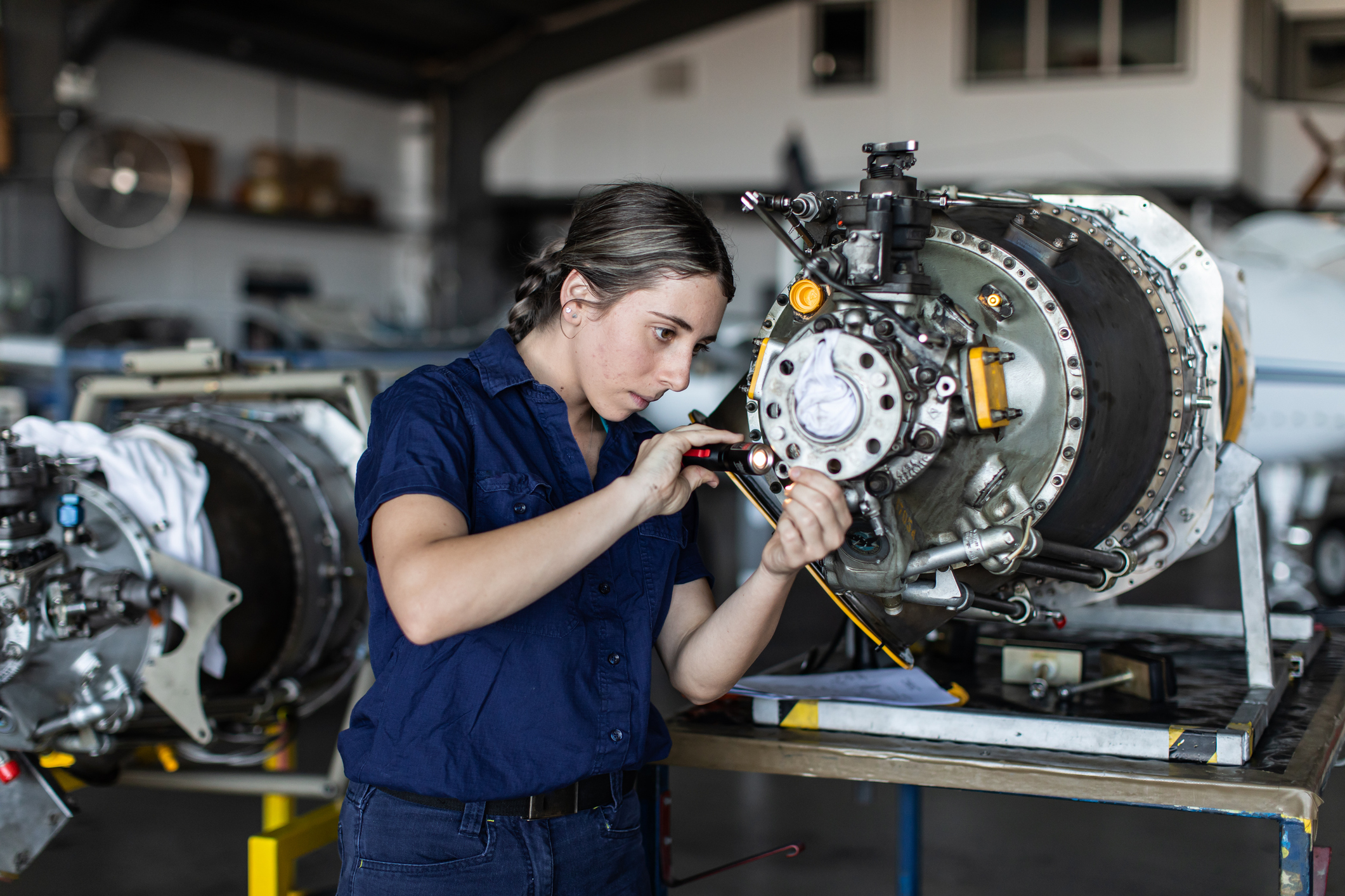 A woman working on an aircraft engine.