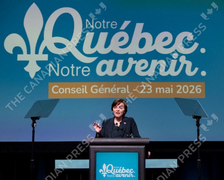 La ministre Christine Fréchette prononce un discours derrière un lutrin lors du Conseil général de la Coalition Avenir Québec, le 23 mai 2026. En arrière-plan, un grand écran bleu affiche le slogan « Notre Québec. Notre avenir. » accompagné du logo fleurdelisé du parti.