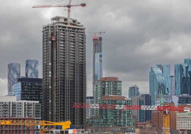 The skyline is filled with glass towers and a couple of cranes.