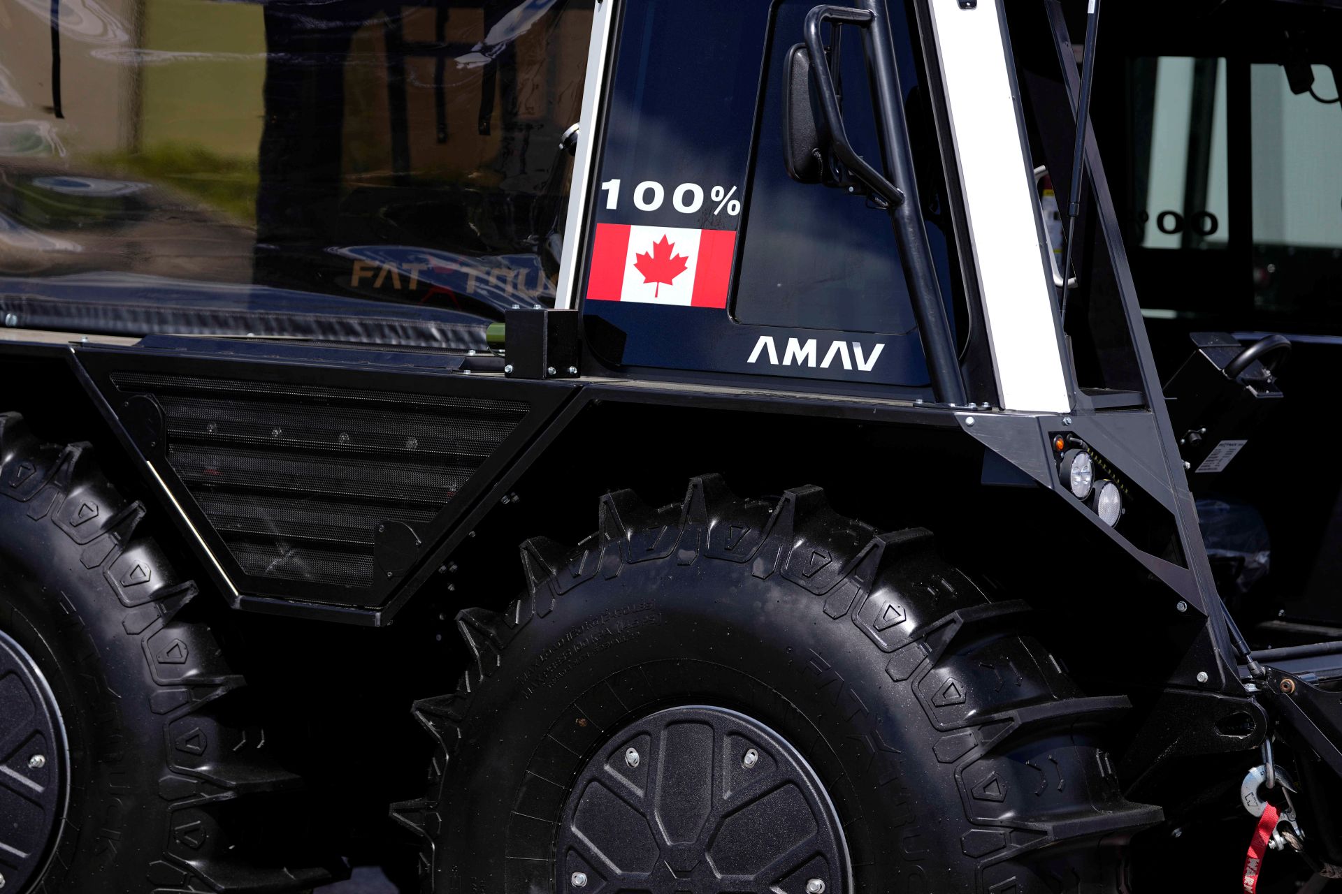 The truck is black with big wheels.