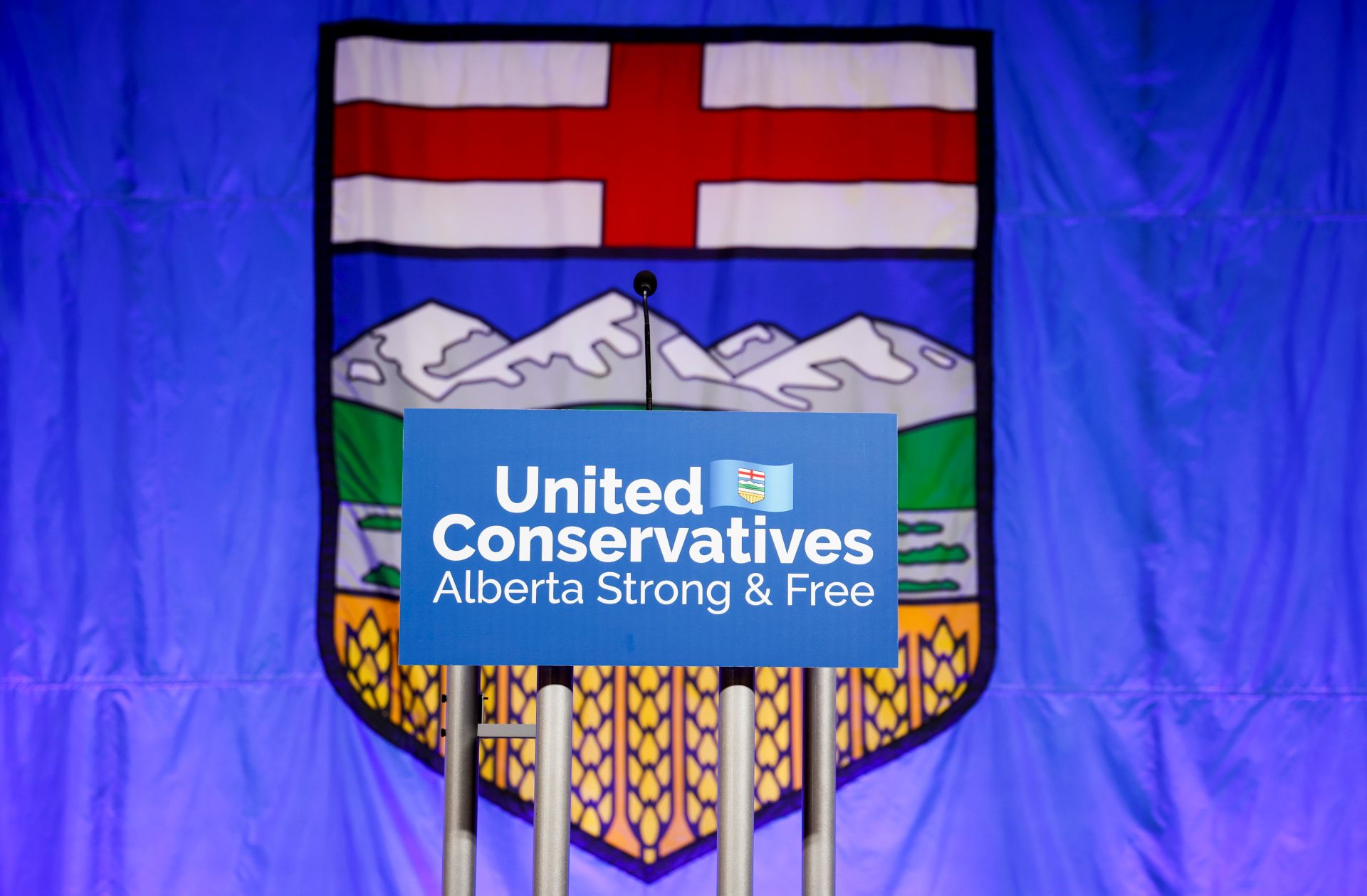 Une pancarte du Parti conservateur uni de l’Alberta posée sur un podium est visible devant le drapeau de l’Alberta.