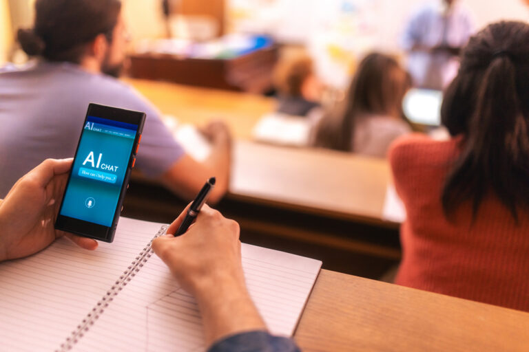 A student using AI app on mobile phone during university lecture in amphitheater.