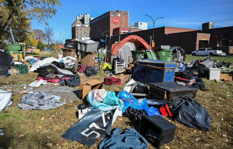 Une tente, des déchets et des effets personnels dans un campement de personnes sans-abri sur la rue Notre-Dame dans l’est de Montréal.