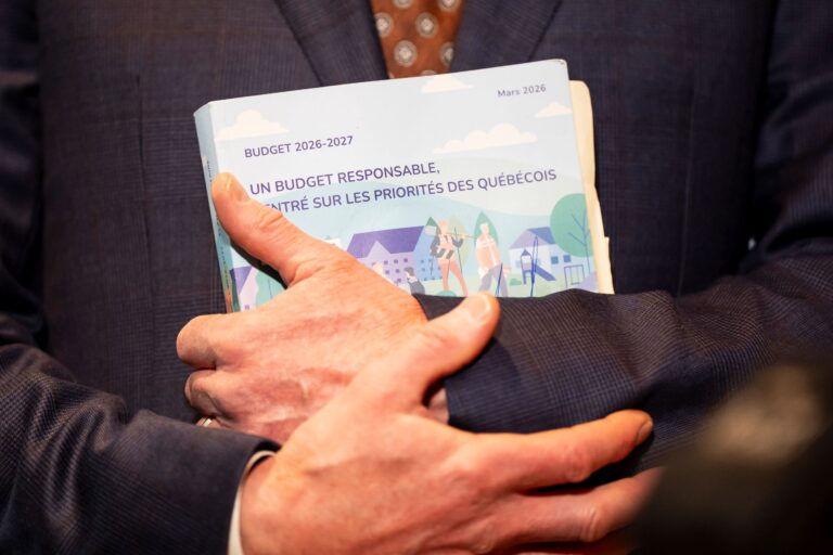 Deux mains tiennent un livre avec le titre «Budget 2026-2027 : un budget responsable centré sur les priorités des Québécois».