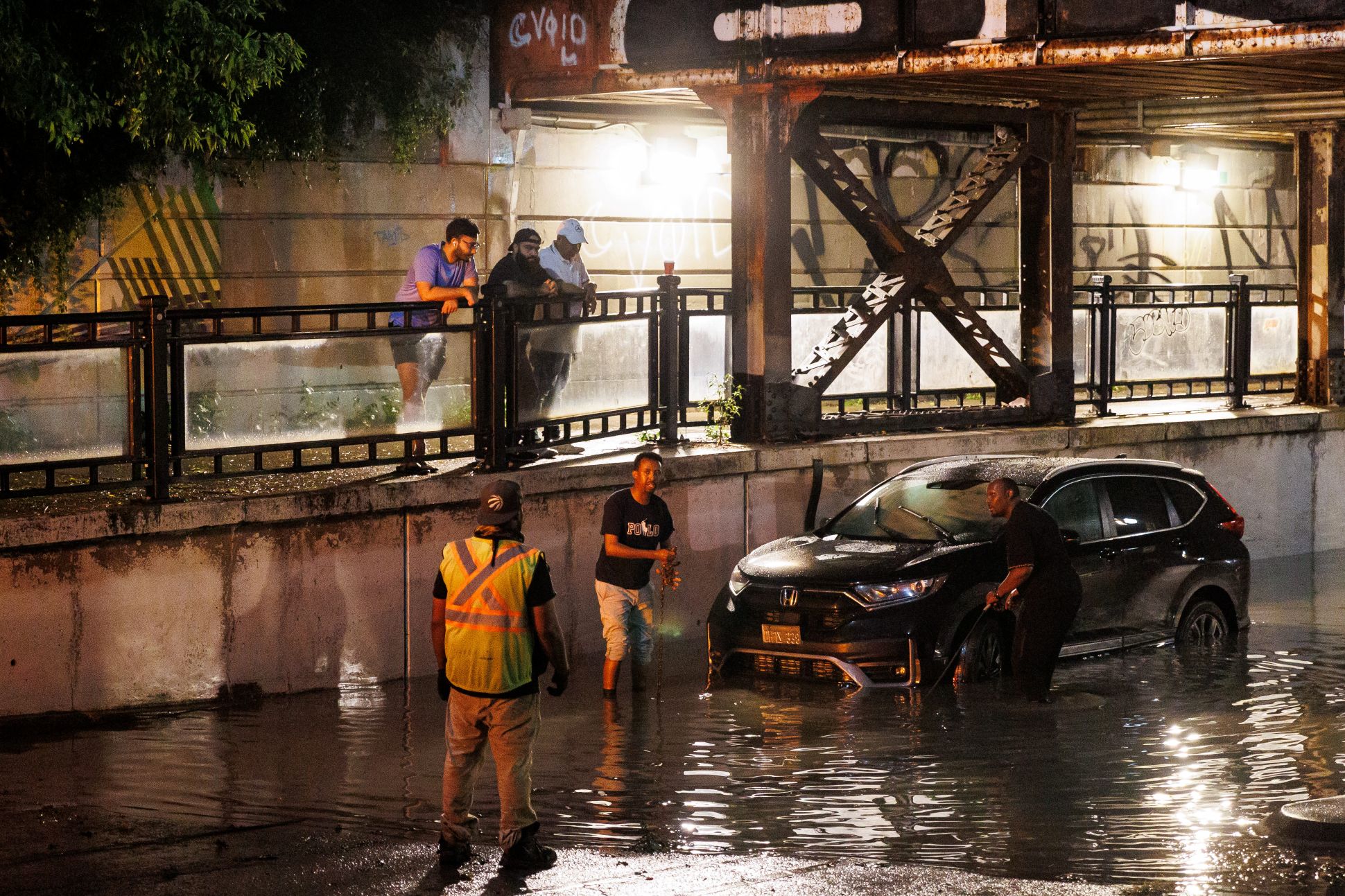 Des personnes s’apprêtent à remorquer une voiture hors d’un passage souterrain inondé pendant une tempête à Toronto, le mercredi 2 septembre 2026. LA PRESSE CANADIENNE/Keito Newman