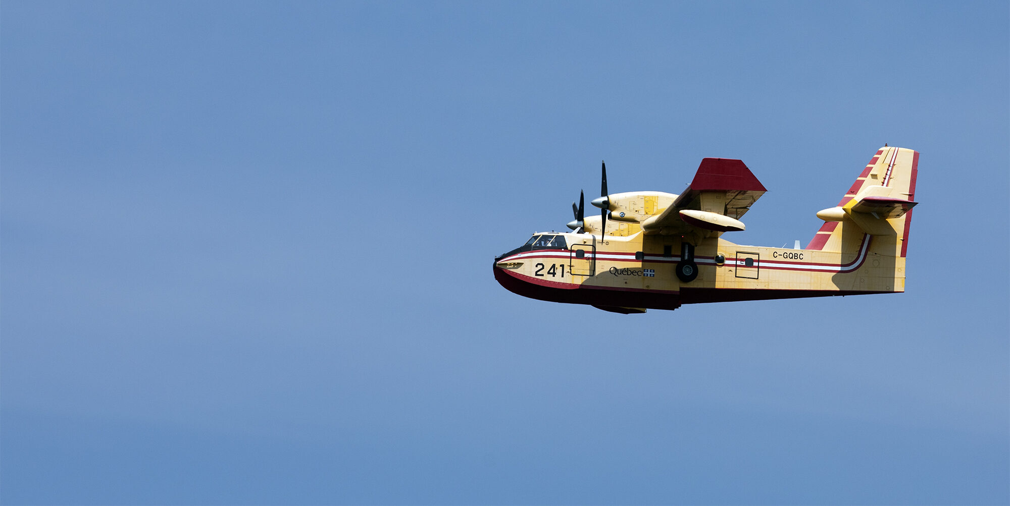 Le CL-415 jaune se détache sur un ciel d’un bleu éclatant.