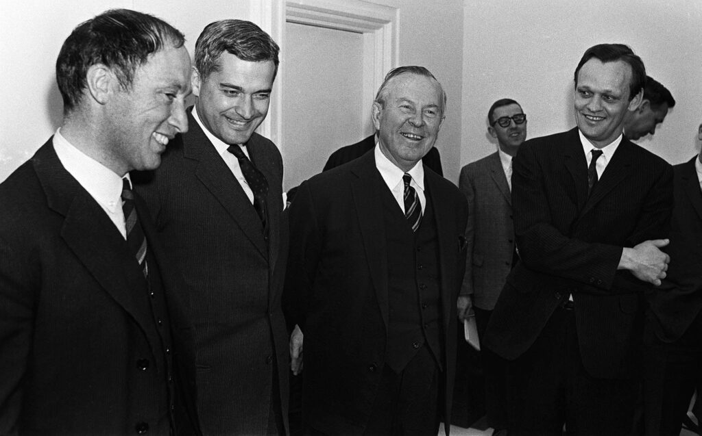 A black and white image of four former prime ministers smiling. 